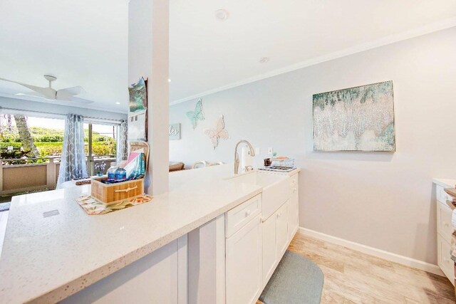 525 Aleka Lp Unit J2, Kapaa, HI 96746 - kitchen featuring crown molding, white cabinetry, a sink, baseboards, and light stone countertops