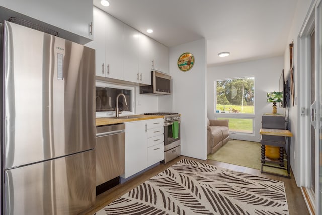 32-491 Piha Kahuku Rd, Ninole, HI 96773 - kitchen featuring appliances with stainless steel finishes, a sink, white cabinetry, wooden counters, and recessed lighting