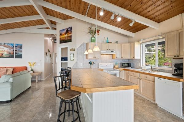 87-3216 Ama Rd, Captain Cook, HI 96704 - kitchen featuring white appliances, under cabinet range hood, track lighting, wood ceiling, and a kitchen breakfast bar