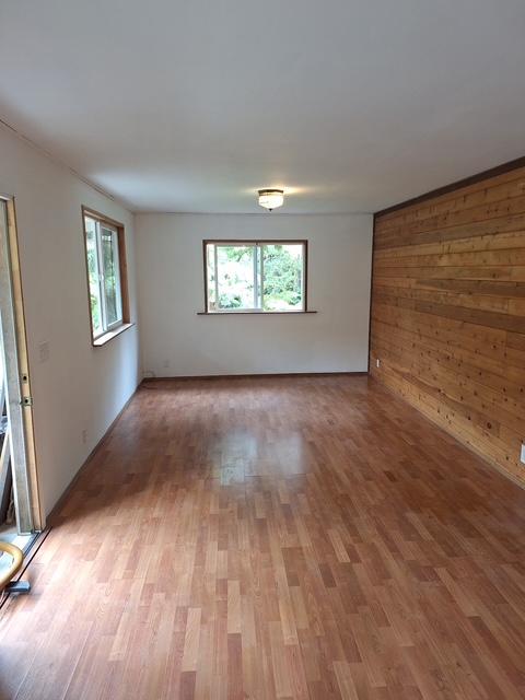 11-3791 4th St, Volcano, HI 96785 - empty room with healthy amount of natural light, light wood-style floors, and wood walls