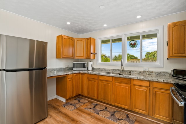 5587 Kawaihau Rd, Kapaa, HI 96746 - kitchen featuring stainless steel appliances, a sink, light wood-style flooring, brown cabinetry, and recessed lighting