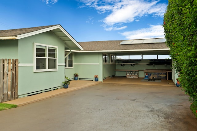 5587 Kawaihau Rd, Kapaa, HI 96746 - view of home's exterior with roof with shingles, solar panels, stucco siding, and driveway