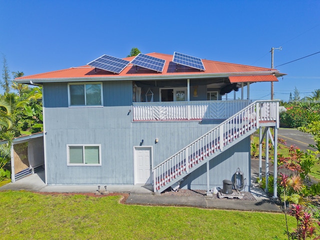 12-7042 Wehelauniu St, Pahoa, HI 96778 - rear view of property featuring solar panels, stairway, a lawn, and metal roof