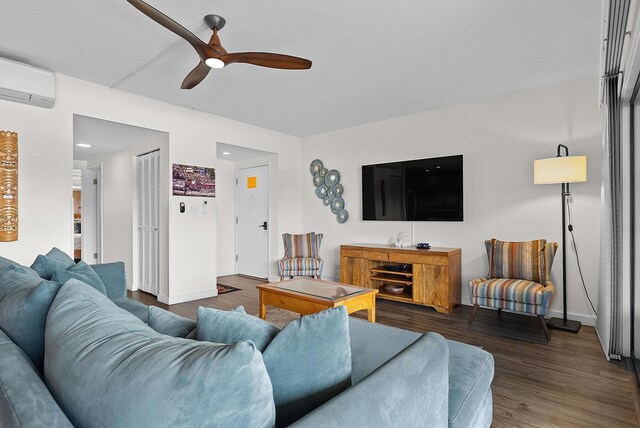 75-5719 Alii Dr Unit 307, Kailua-Kona, HI 96740 - living area featuring wood finished floors, a wall mounted air conditioner, a ceiling fan, and baseboards