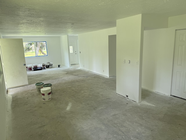 13-3436 Alapai St, Pahoa, HI 96778 - unfurnished living room featuring unfinished concrete floors and a textured ceiling