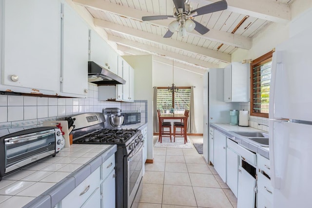 171 Lani Alii Pl, Kapaa, HI 96746 - kitchen with stainless steel range with gas stovetop, under cabinet range hood, tile countertops, freestanding refrigerator, and a ceiling fan