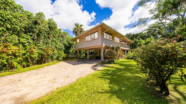 5-6691 Kuhio Hwy, Hanalei, HI 96714 - rear view of house featuring asphalt driveway, a yard, and a carport