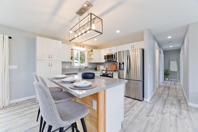 15-2804 Maikoiko St, Pahoa, HI 96778 - kitchen with appliances with stainless steel finishes, white cabinets, open shelves, a breakfast bar area, and light wood-style floors