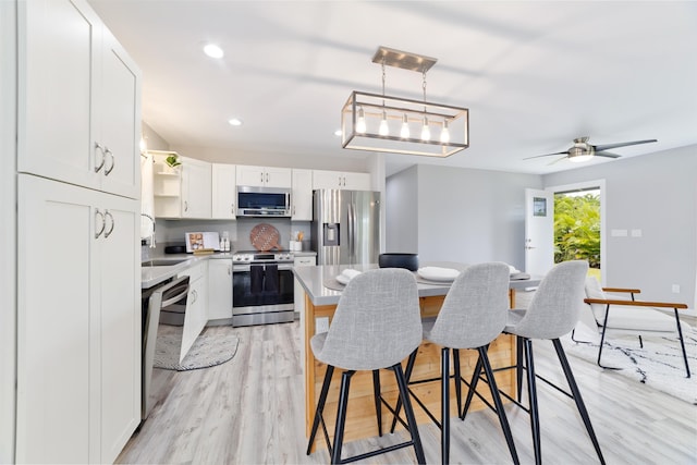 15-2804 Maikoiko St, Pahoa, HI 96778 - kitchen with stainless steel appliances, a sink, open shelves, a kitchen breakfast bar, and white cabinetry