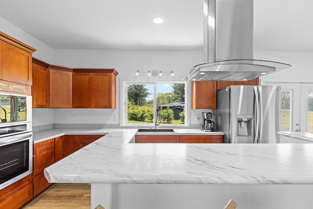 16-2028 35th Ave, Keaau, HI 96749 - kitchen featuring stainless steel refrigerator with ice dispenser, island exhaust hood, a sink, light wood-style flooring, and light stone counters