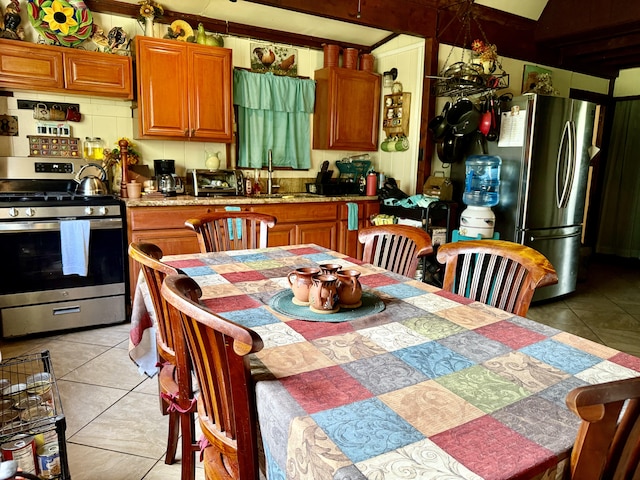 16-233 Orchid Land Dr, Keaau, HI 96749 - kitchen featuring appliances with stainless steel finishes, a sink, light tile patterned flooring, light countertops, and brown cabinetry