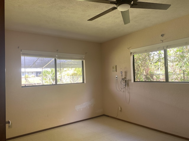 16-1397 35th Ave, Keaau, HI 96749 - empty room with plenty of natural light, light flooring, a ceiling fan, a textured ceiling, and baseboards