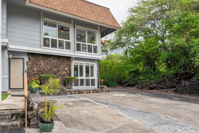 75-6150 Alii Dr Unit 7, Kailua-Kona, HI 96740 - rear view of house with roof with shingles and stone siding