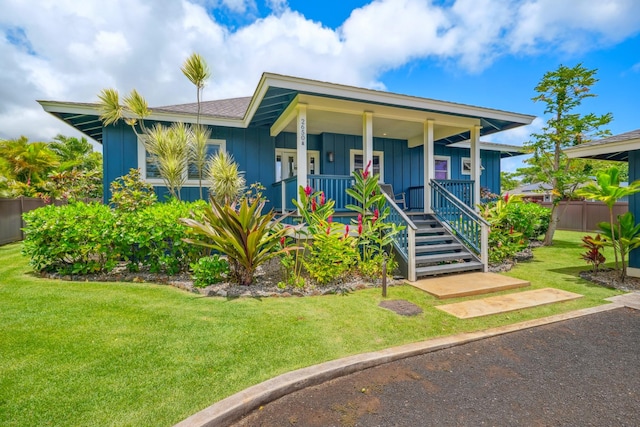 2650 Halalu St, Koloa, HI 96756 - view of front of house with board and batten siding, a front lawn, and covered porch