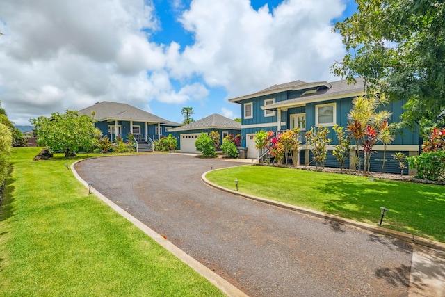 2650 Halalu St, Koloa, HI 96756 - split level home featuring board and batten siding, a garage, a front yard, and stairs