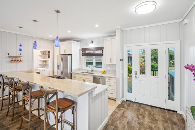 2650 Halalu St, Koloa, HI 96756 - kitchen with stainless steel appliances, a sink, a breakfast bar area, crown molding, and wood finished floors