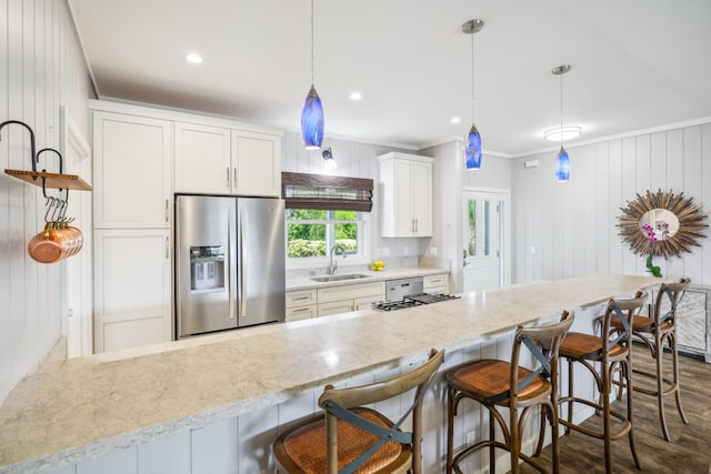 2650 Halalu St, Koloa, HI 96756 - kitchen featuring stainless steel fridge with ice dispenser, a sink, crown molding, white cabinets, and a kitchen bar