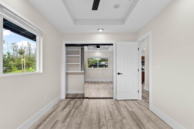 16-2168 Tree Fern Dr, Pahoa, HI 96778 - unfurnished bedroom with light wood-type flooring, baseboards, a ceiling fan, and a tray ceiling
