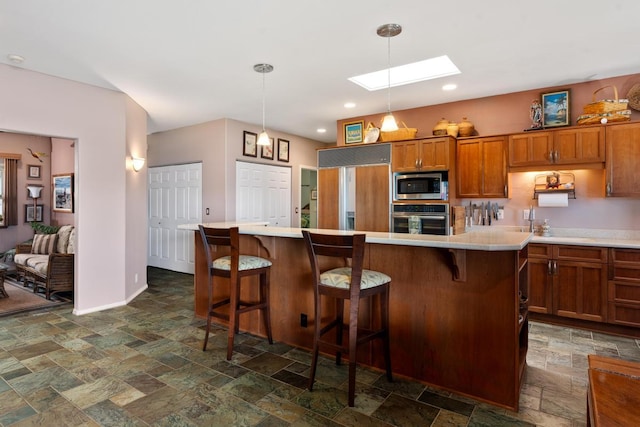 73-4685 Hina Lani St, Kailua-Kona, HI 96740 - kitchen featuring built in appliances, stone tile floors, a skylight, brown cabinetry, and light countertops