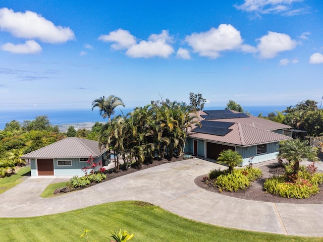 73-4566 Kukuki St, Kailua-Kona, HI 96740 - view of front of property featuring curved driveway, roof mounted solar panels, a metal roof, and a water view