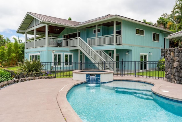 73-4566 Kukuki St, Kailua-Kona, HI 96740 - back of house featuring a pool with connected hot tub, a patio area, a metal roof, and a balcony