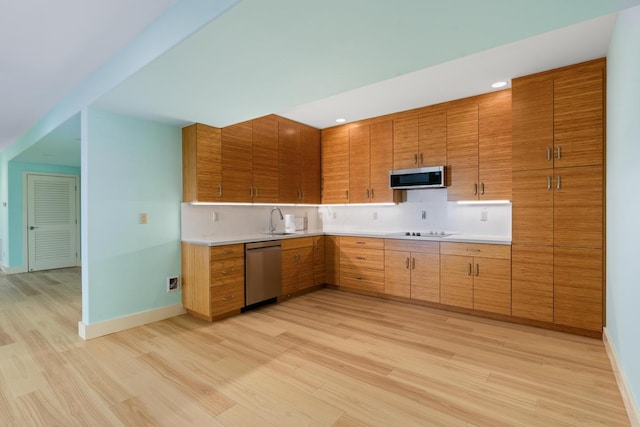 73-4566 Kukuki St, Kailua-Kona, HI 96740 - kitchen featuring appliances with stainless steel finishes, light wood finished floors, backsplash, light countertops, and brown cabinets