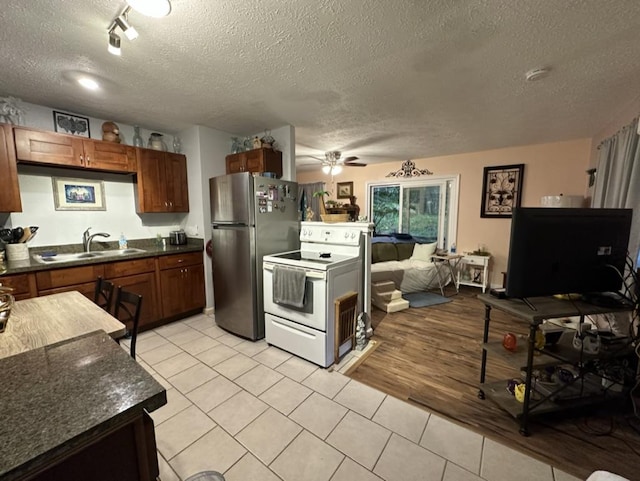 14-682 Kehau Rd, Pahoa, HI 96778 - kitchen featuring electric range, a sink, a textured ceiling, freestanding refrigerator, and dark countertops