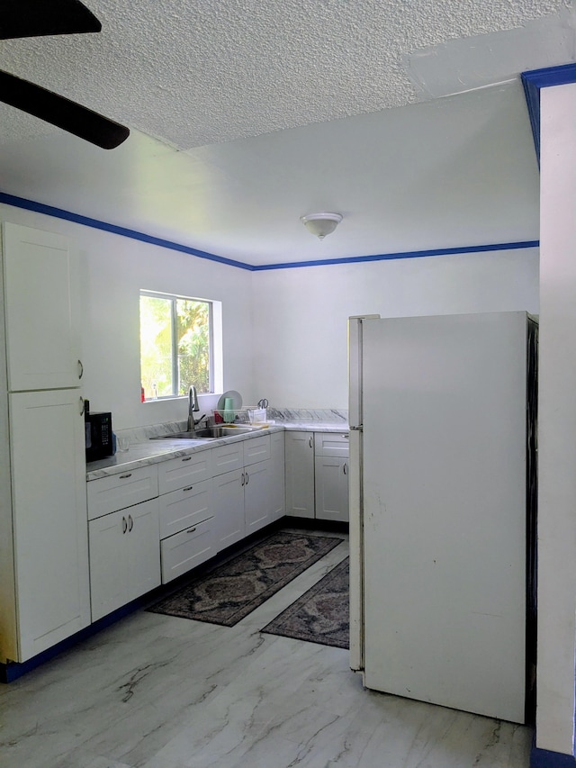 15-2714 Nenue St, Pahoa, HI 96778 - kitchen with freestanding refrigerator, a sink, light countertops, a textured ceiling, and white cabinets