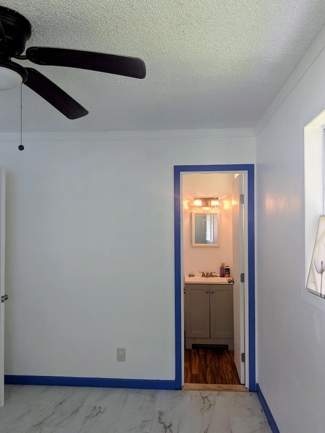 15-2714 Nenue St, Pahoa, HI 96778 - unfurnished bedroom featuring light marble finish floors, a textured ceiling, baseboards, ensuite bath, and ceiling fan
