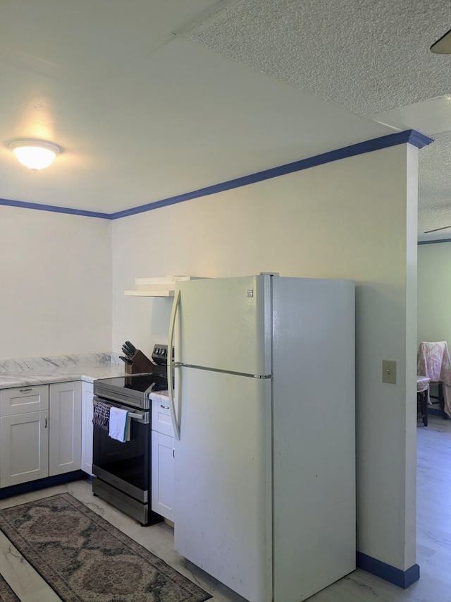 15-2714 Nenue St, Pahoa, HI 96778 - kitchen with freestanding refrigerator, electric stove, white cabinets, and a textured ceiling