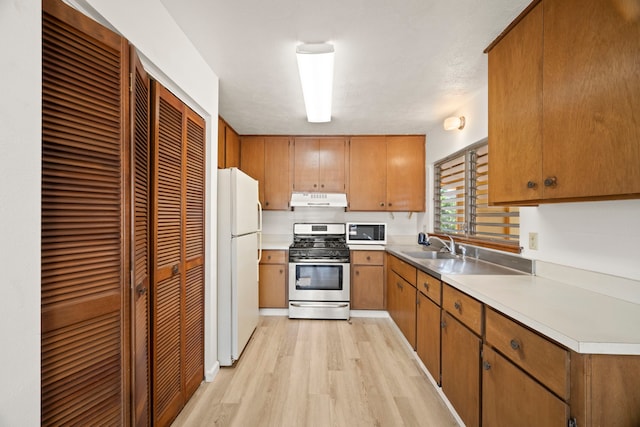 522 Aewa St, Eleele, HI 96705 - kitchen with white appliances, under cabinet range hood, light wood-type flooring, brown cabinetry, and light countertops