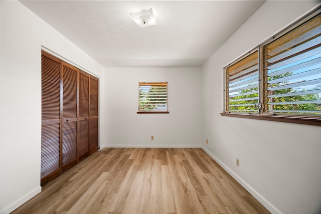 522 Aewa St, Eleele, HI 96705 - unfurnished bedroom featuring multiple windows, light wood-type flooring, and a closet