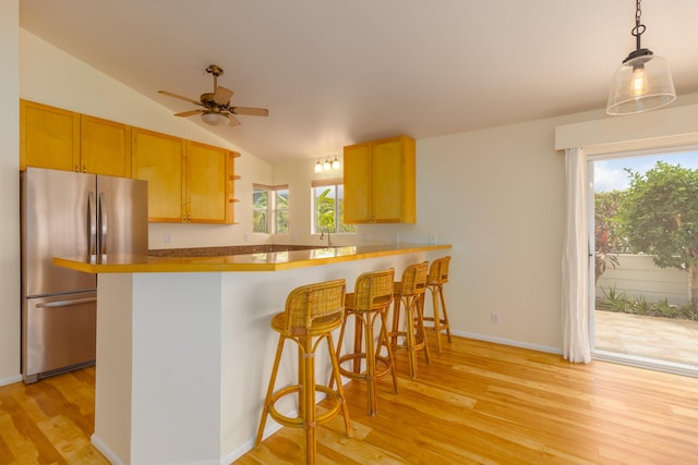 75-252 Nani Kailua Dr Unit 23, Kailua-Kona, HI 96740 - kitchen with freestanding refrigerator, lofted ceiling, light wood finished floors, ceiling fan, and a breakfast bar area