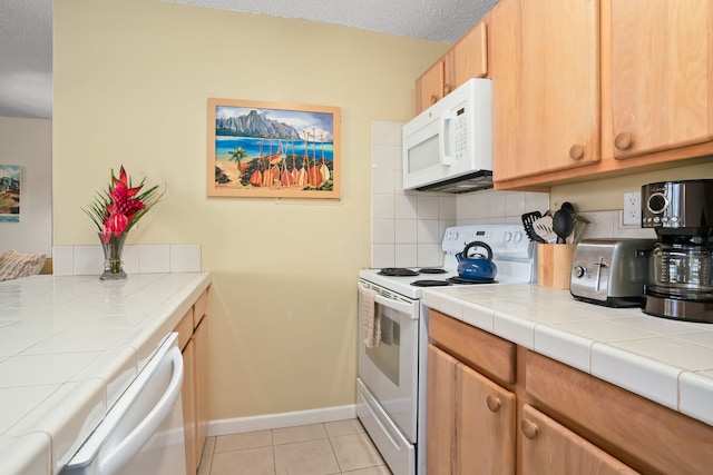 4330 Kauai Beach Dr Unit E5, Lihue, HI 96766 - kitchen with white appliances, backsplash, tile counters, light tile patterned flooring, and a textured ceiling