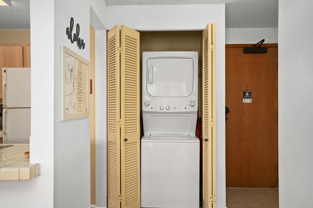 4330 Kauai Beach Dr Unit E5, Lihue, HI 96766 - washroom featuring stacked washer / drying machine, a textured ceiling, and tile patterned flooring