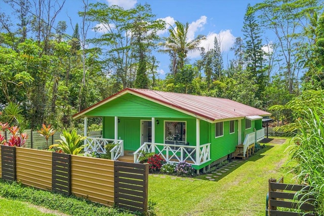 14-882 Kehau Rd, Pahoa, HI 96778 - view of front of house with covered porch, a front yard, and metal roof