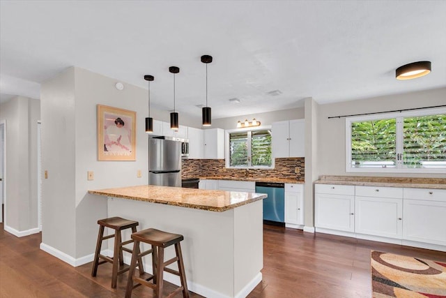 14-882 Kehau Rd, Pahoa, HI 96778 - kitchen featuring appliances with stainless steel finishes, dark wood-type flooring, decorative backsplash, white cabinets, and a peninsula