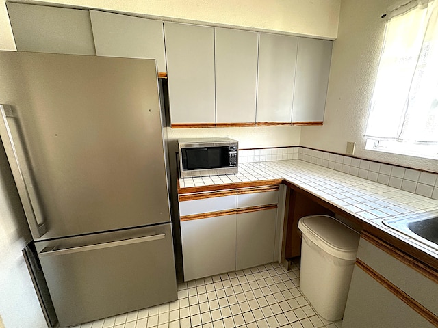 73-1276 Kaiminani Dr, Kailua-Kona, HI 96740 - kitchen with appliances with stainless steel finishes, tile counters, and light tile patterned floors