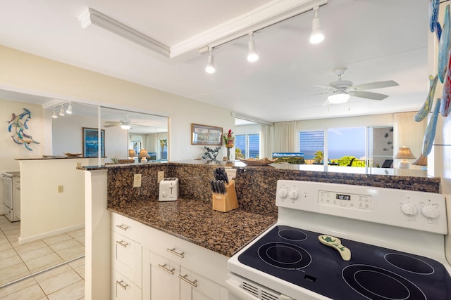 1763 Pee Rd Unit 304, Koloa, HI 96756 - kitchen with white range with electric stovetop, ceiling fan, rail lighting, light tile patterned floors, and white cabinets