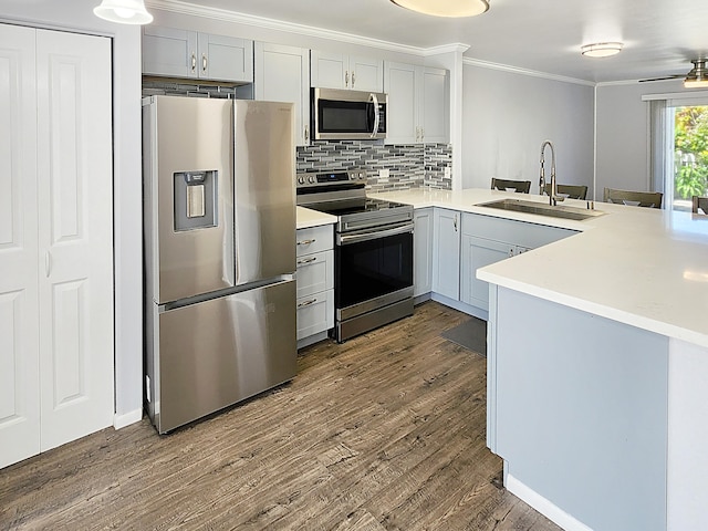 75-6081 Alii Dr Unit Dd102, Kailua-Kona, HI 96740 - kitchen featuring appliances with stainless steel finishes, a sink, dark wood-style floors, tasteful backsplash, and crown molding