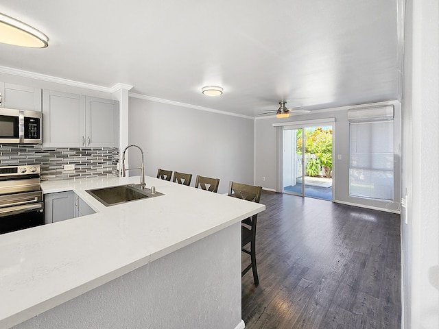 75-6081 Alii Dr Unit Dd102, Kailua-Kona, HI 96740 - kitchen featuring a sink, appliances with stainless steel finishes, a kitchen bar, light countertops, and dark wood finished floors