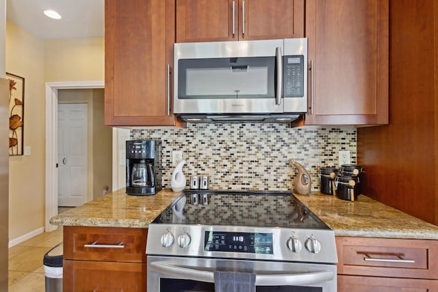 75-149 Kamilo St, Kailua-Kona, HI 96740 - kitchen featuring appliances with stainless steel finishes, backsplash, light stone counters, and light tile patterned floors