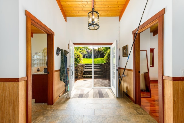 76-6319 Leone St, Kailua-Kona, HI 96740 - entrance foyer with wood ceiling, wainscoting, stone finish floors, a chandelier, and wooden walls