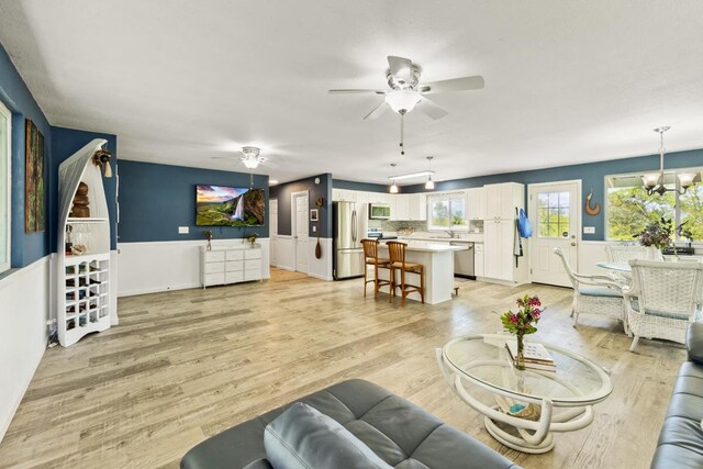 15-1653 28th Ave, Keaau, HI 96749 - living area with ceiling fan, a chandelier, light wood finished floors, and a wainscoted wall