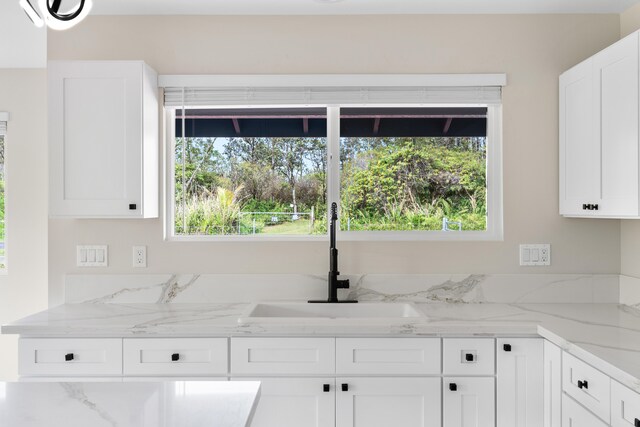 16-2147 Stardust Dr, Pahoa, HI 96778 - kitchen featuring white cabinetry, healthy amount of natural light, a sink, and light stone countertops
