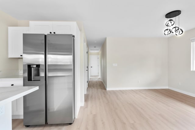 16-2147 Stardust Dr, Pahoa, HI 96778 - kitchen featuring stainless steel fridge with ice dispenser, white cabinetry, light wood-type flooring, and baseboards