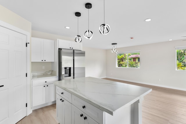 16-2147 Stardust Dr, Pahoa, HI 96778 - kitchen with stainless steel refrigerator with ice dispenser, light wood-type flooring, hanging light fixtures, a center island, and white cabinetry