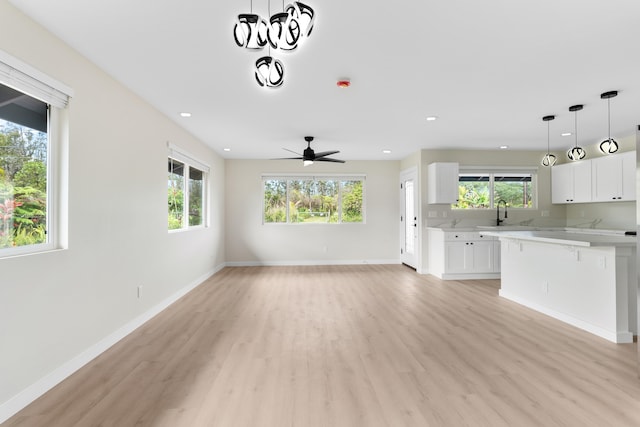 16-2147 Stardust Dr, Pahoa, HI 96778 - unfurnished living room featuring healthy amount of natural light, light wood-style flooring, ceiling fan, baseboards, and recessed lighting