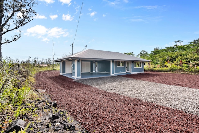 16-2147 Stardust Dr, Pahoa, HI 96778 - view of front facade with dirt driveway, a patio, and metal roof
