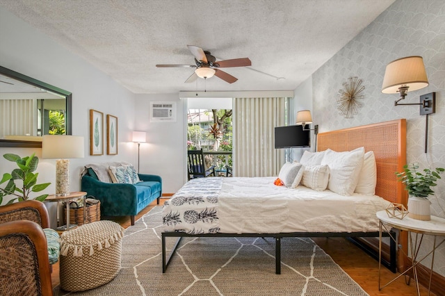 75-5776 Kuakini Hwy Unit 123, Kailua-Kona, HI 96740 - bedroom featuring wallpapered walls, wood finished floors, a wall unit AC, a textured ceiling, and ceiling fan